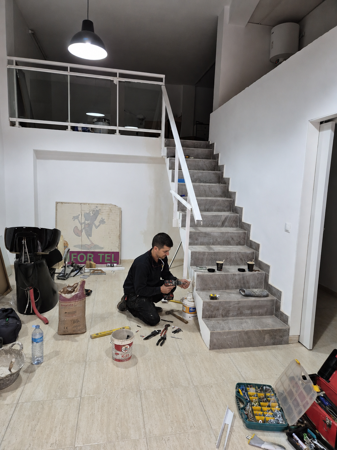 En Roger treballant en una escala interior amb eines professionals